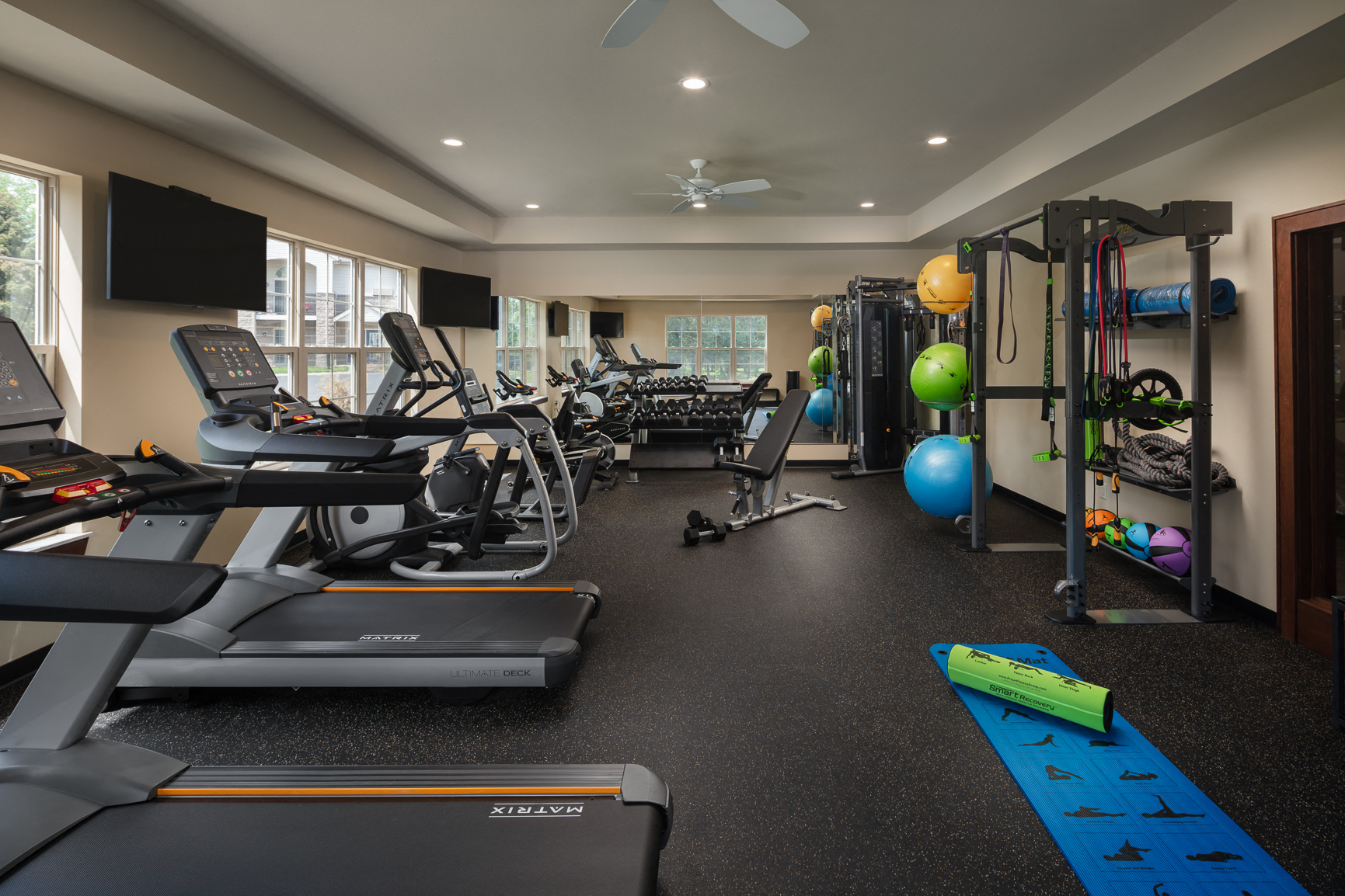 a gym with treadmills and other exercise equipment and a tv